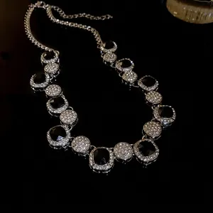 Elegant geometric necklace with black stones and pavé rhinestones on black background