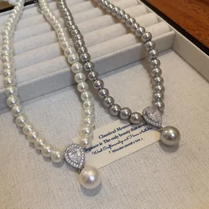 Detailed view of French vintage pearl necklaces featuring elegant zircon teardrop pendants