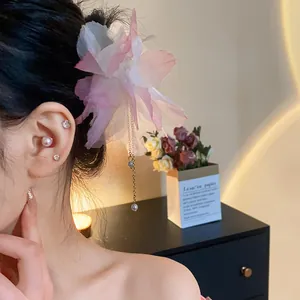 Detail view of pink chiffon flower hair pin with elegant pearl tassel on model