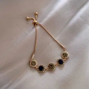 Detailed view of gold-plated adjustable bracelet with colorful round crystal charms.