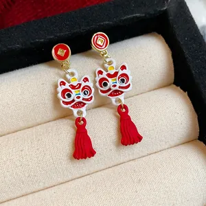 Detailansicht traditioneller chinesischer Löwentanz-Ohrringe mit roten Quasten und Emaille.