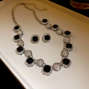Detailed view of the rhinestone geometric necklace and earrings set with black square stones