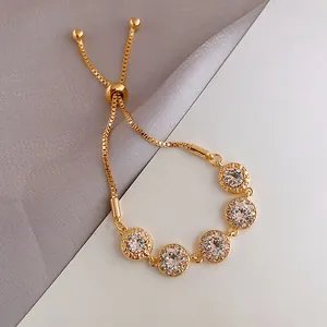 Detail of gold-plated bracelet with five sparkling round stones and bolo chain