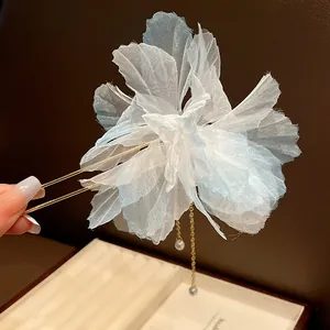 Detail view of an elegant light blue chiffon flower hair fork with delicate pearl tassels