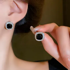 Detailed view of elegant square black gemstone stud earrings with a crystal halo