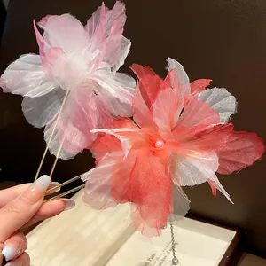 Detailed macro shot of handmade chiffon flower hairpins featuring elegant pearl tassels