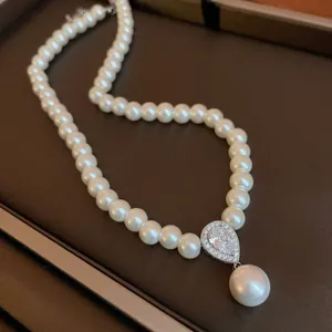 Detailed close-up of a French retro pearl necklace with zircon teardrop pendant