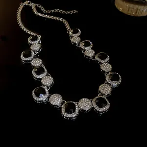 Close-up macro view of luxury geometric necklace with black gems and sparkling rhinestones