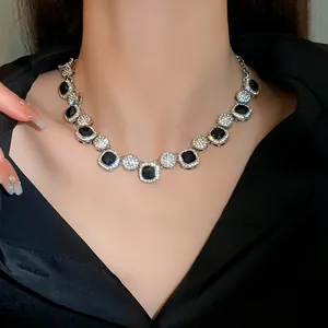 Close-up of elegant geometric rhinestone necklace with black stones on model