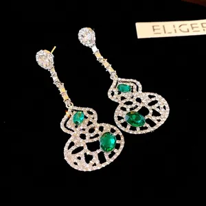 Elegant hollow-out gourd drop earrings featuring green crystals and sparkling stones