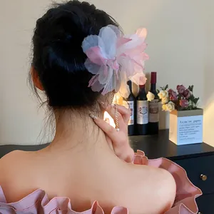 Elegant pink chiffon flower hair pin with pearl tassels shown on a model's classic updo