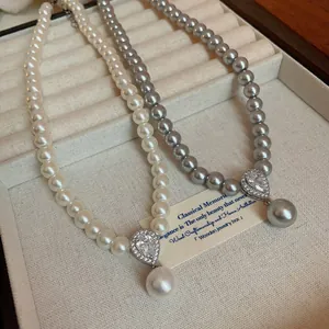 Detail view of French retro pearl necklaces with zircon teardrop pendants in white and gray