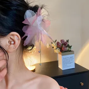 Close-up detail of vintage chiffon flower hairpin with elegant pearl tassel worn by model