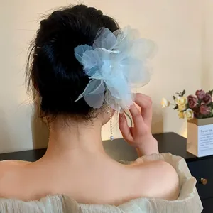 Close-up view of a light cyan chiffon flower hair stick with elegant pearl tassels.