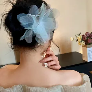 Detailed view of light blue chiffon flower hair pin with elegant pearl tassel detail