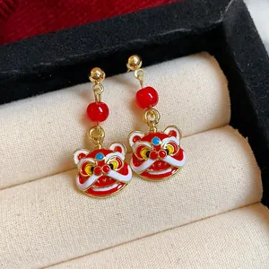 Detailansicht der roten Löwentanz-Emaille-Ohrringe mit Goldakzenten in einer Schmuckbox