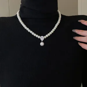 Detail shot of a French retro pearl necklace with a sparkling zircon teardrop pendant