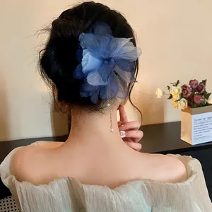 Elegant back view of model wearing a blue chiffon flower hairpin with pearl tassel accessory