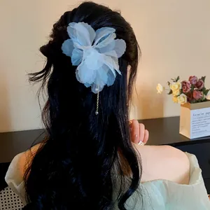 Detailed view of a light blue chiffon flower hair pin featuring a delicate pearl tassel.