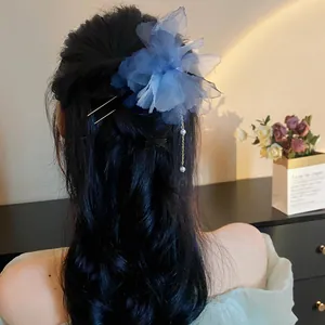Elegant detailed view of a blue chiffon flower hair pin with pearl tassel in styled hair