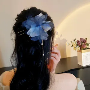 Close-up of blue chiffon flower hair pin with pearl tassel on model's hair