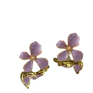 Elegant purple enamel flower earrings with pearls and gold stems for a sweet summer look.