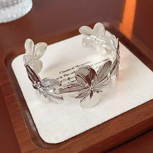 Vintage silver-colored metal cuff bracelet featuring oversized engraved floral patterns.