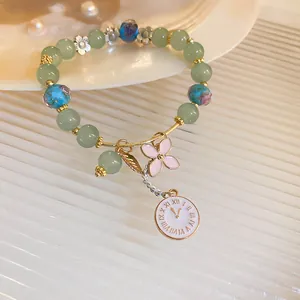 Detailed close-up of a vintage style beaded bracelet with floral glass beads and charms