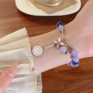Detail of glass bead bracelet with flower and clock charms in new Chinese style