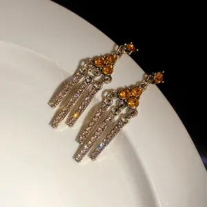 Elegant vintage gold-tone tassel earrings featuring amber stones and sparkling rhinestones.