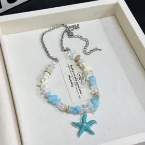 Dainty ocean-themed necklace featuring blue starfish, pearls, and clear stones detail.