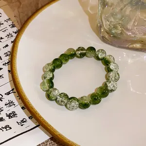 Macro detail of elegant green and clear crackle glass beads on a stylish artisan bracelet