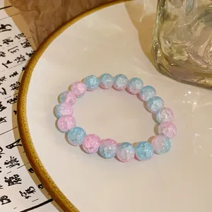 Macro view of pink and blue crackle glass beads on a neo-Chinese style bracelet.