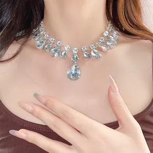 Detailed close-up showing elegant teardrop crystal necklace with sparkling rhinestones