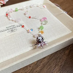 Nahaufnahme einer bunten Perlenkette mit einem niedlichen Oktopus-Anhänger aus Glas