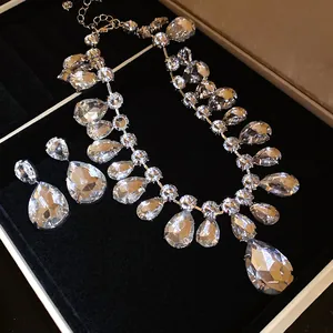 Close-up of elegant teardrop crystal necklace and earring set in a black velvet gift box