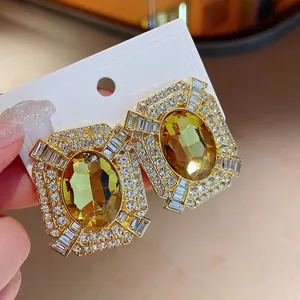 Close-up of vintage square gold earrings with yellow crystal and rhinestones