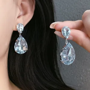 Detailed view of elegant silver needle teardrop earrings with sparkling rhinestones