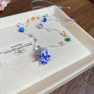 Nahaufnahme einer handgefertigten blauen Oktopus-Halskette mit vielen bunten Perlen
