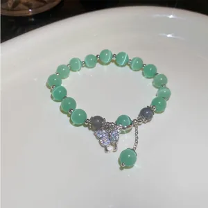 Elegant light green cat's eye beaded bracelet with a sparkling crystal butterfly charm detail