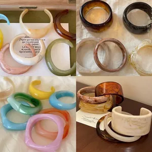 Detailed view of colorful marbled acrylic bangles with irregular wide-band designs