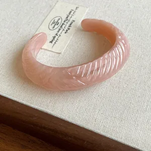 Minimalist peach pink translucent resin cuff bracelet with wavy leaf texture detail