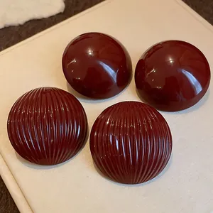 Detailed macro shot of dark red striped and smooth semi-circular metal stud earrings