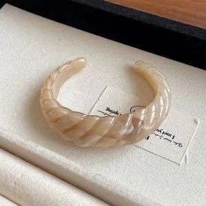 Chunky resin open cuff bracelet with beige marbled twisted geometric design pattern