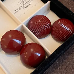 Macro detail of vintage red striped and smooth semi-circular earrings in a jewelry box