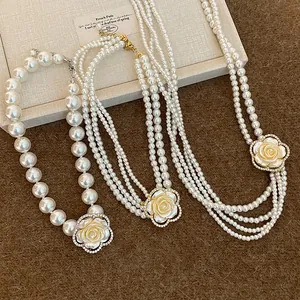 Detail view of French style pearl necklaces featuring elegant rhinestone flower pendants