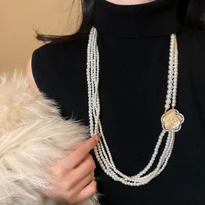 Elegant multi-strand pearl necklace featuring a sparkling crystal camellia flower pendant