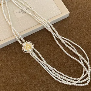 Macro view of multi-strand pearl necklace with rhinestone camellia flower pendant