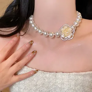 Close-up of elegant French pearl necklace with rhinestone-encrusted flower pendant.