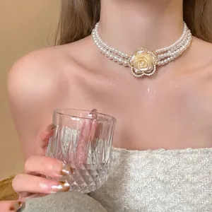 Detailed shot of elegant triple-strand pearl choker with a rhinestone flower pendant